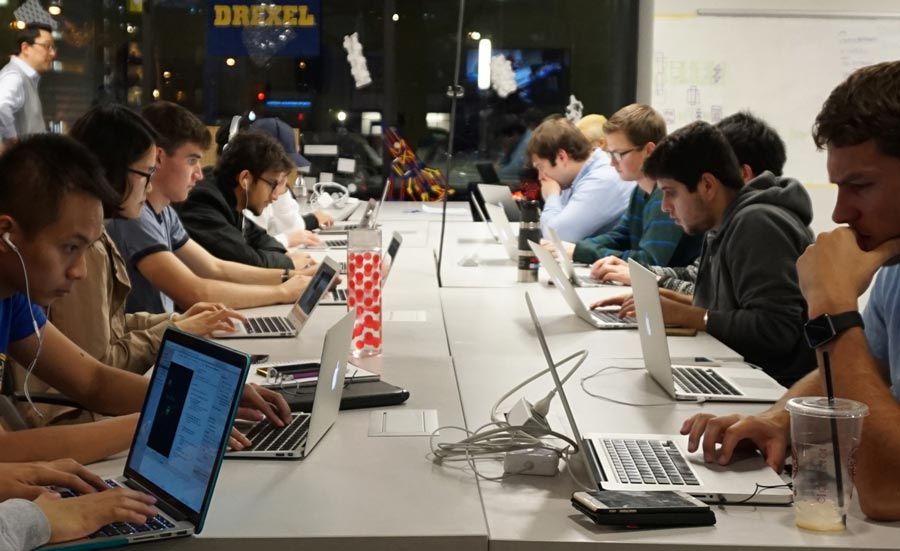 有膝上型计算机的学生坐在一个长的桌子在drexel的兴奋中心。