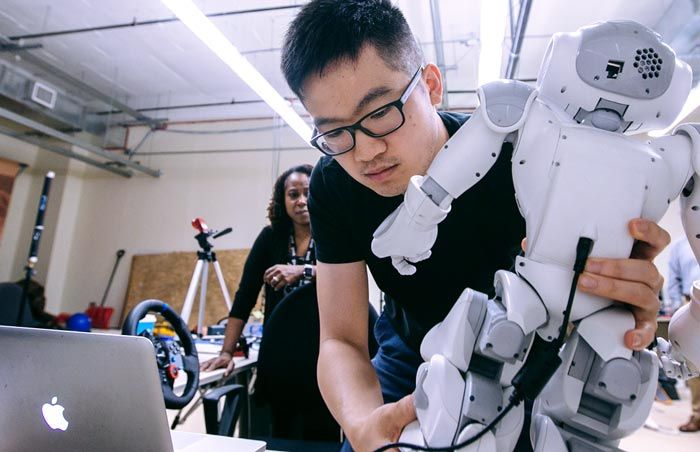 研究生Jin Xu在实验室里搭建NAO。一根电缆将机器人连接到笔记本电脑上。